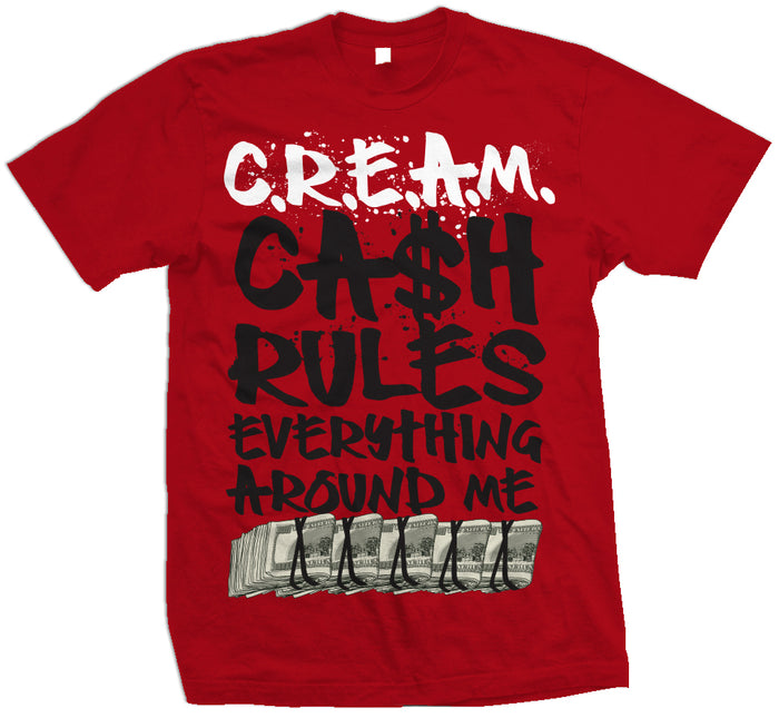 Red T-shirt with white and black cream, cash rules everything around me text and hundred dollar bill row.