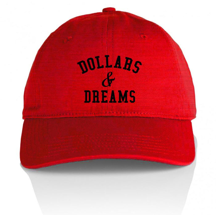 Red dad hat with black dollars & dreams text.